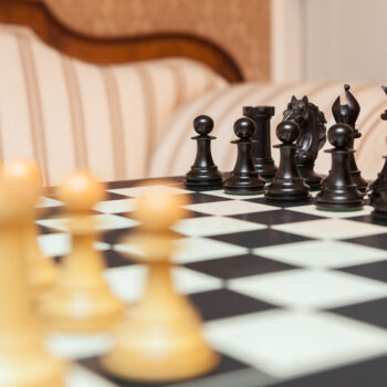 Florence ebony pieces lined up on the Asturias board, with boxwood pieces blurred in the foreground
