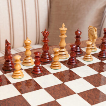 Dali padauk and boxwood pieces arranged for play on the Segovia board