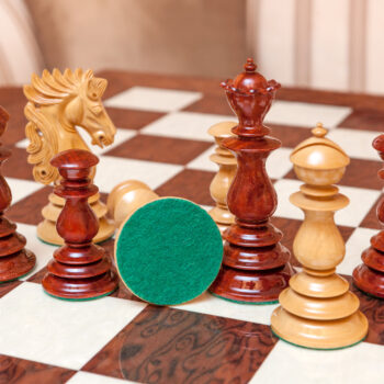 Dali padauk and boxwood pieces on the Segovia board, with one green felt base visible