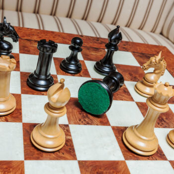 Overhead view of Chevalier ebony and boxwood chess pieces with a green felt base on the 60 cm Toscana chess board