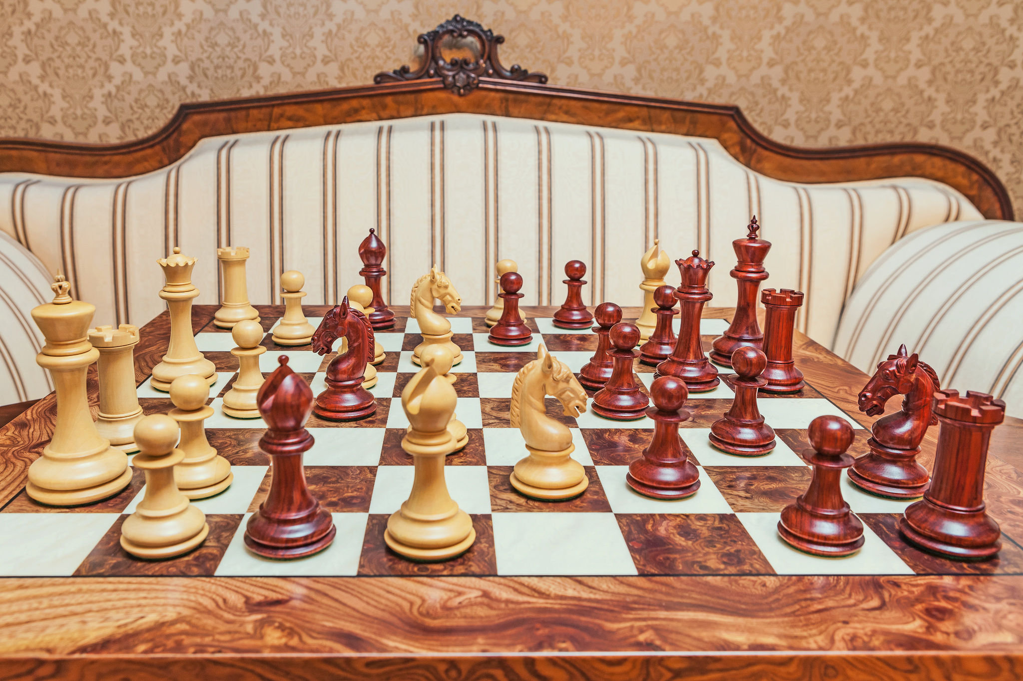 Wide view of Chevalier padauk and boxwood chess pieces during play