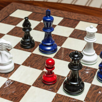 Shown with: 50 cm Cordoba chess board Overhead view of Earl red, white, navy blue and black chess pieces on the 50 cm Cordoba chess board