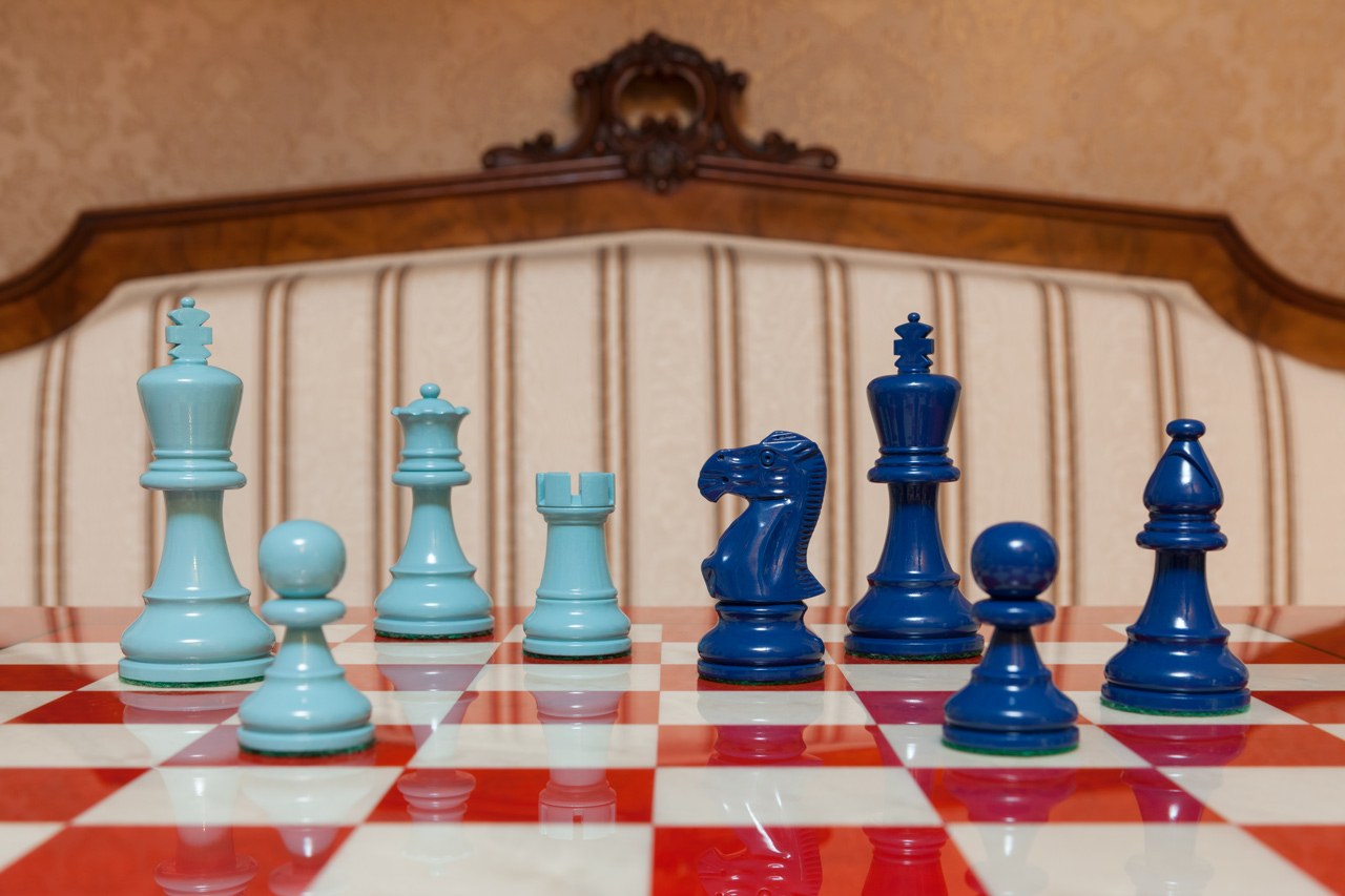Earl Turquoise and Steel Blue Chess Pieces on the red 51 cm ”Bologna” Chess Board