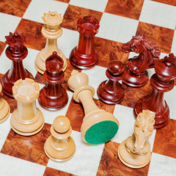 Shown with: 60 cm Toscana chess board Overhead close-up of Florence padauk and boxwood chess pieces with a green felt base on the 60 cm Toscana chess board