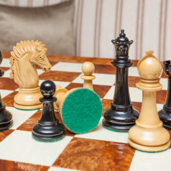 Duke ebony and boxwood pieces on the Da Vinci board, with one green felt base visible