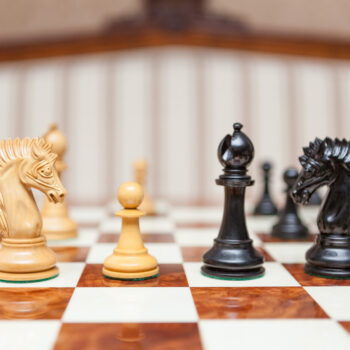 Duke ebony and boxwood pieces facing each other on the Da Vinci board